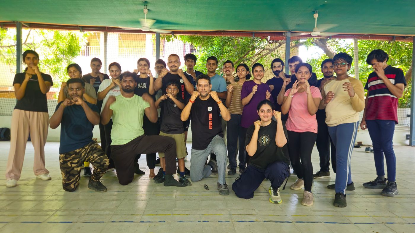 Krav Maga weekend class participants, adults and children, in guard stance with their instructor